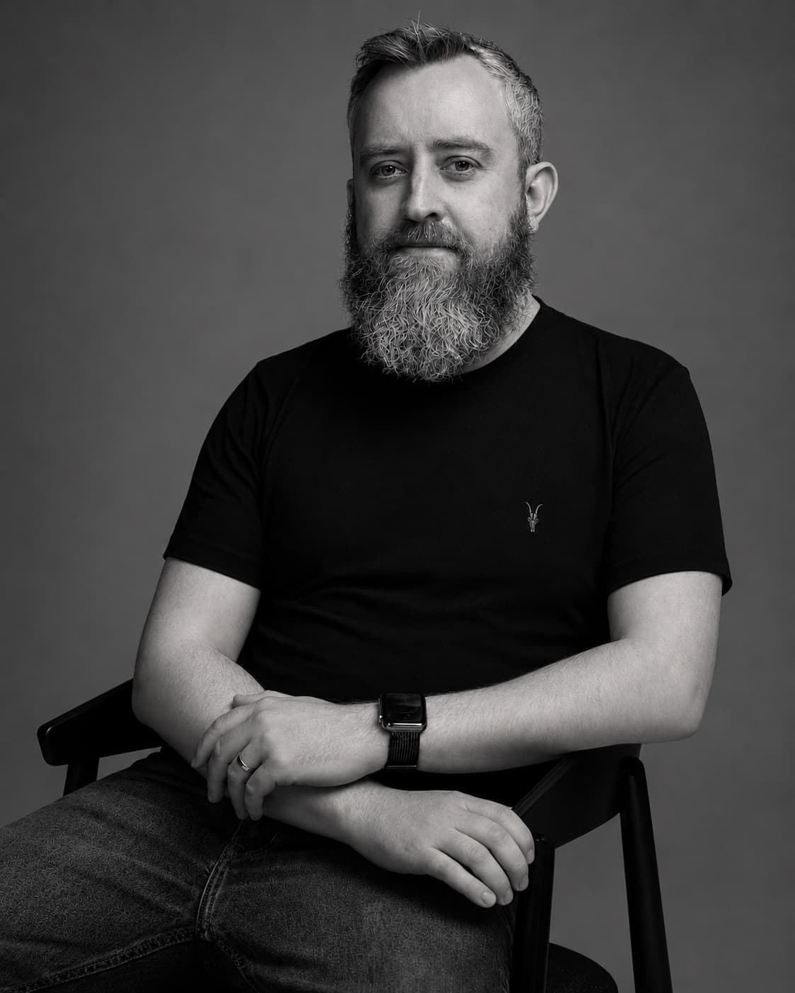 Mark Darling seated, black and white studio portrait