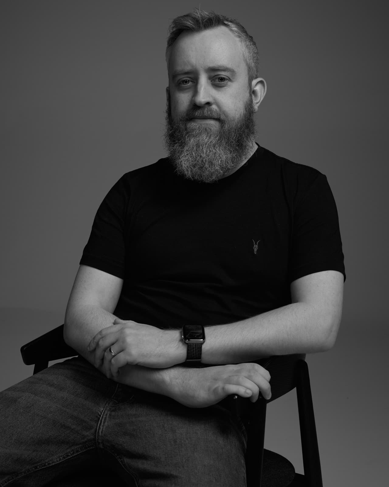 Mark Darling seated, black and white studio portrait